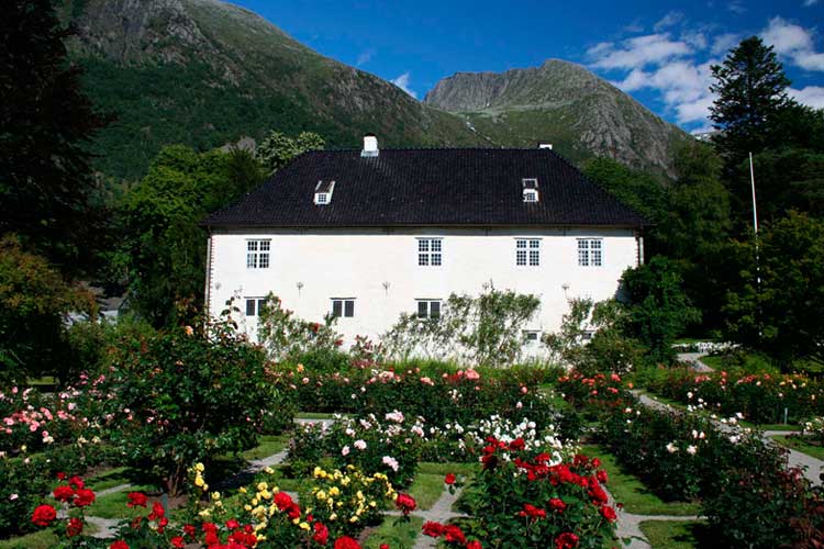 Baroniet Rosendal i Hardanger med rosehagen og Melderskin og Andersfjell i bakgrunnen.